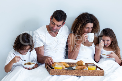 Family having breakfast in bed