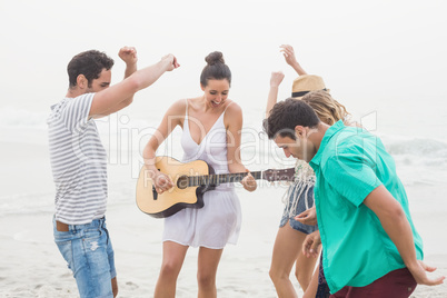 Group of friends playing guitar and dancing