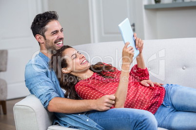 Cheerful couple with digital tablet