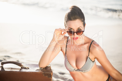 Glamorous woman in bikini looking over sunglasses