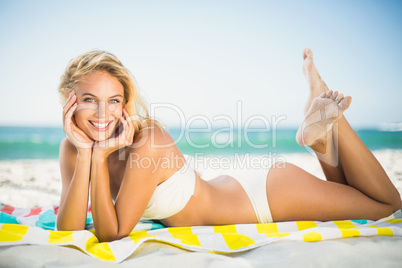 Smiling woman lying on a towel at the beach