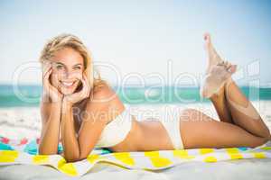 Smiling woman lying on a towel at the beach