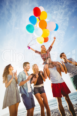 Friends dancing on sand with balloon