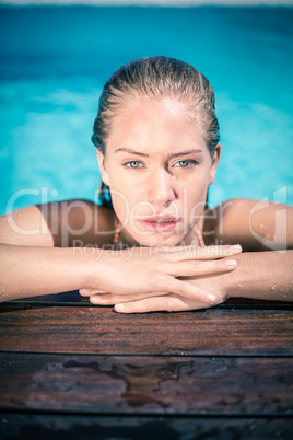 Portrait of beautiful woman leaning on poolside