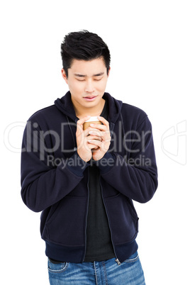 Young man holding disposable coffee cup