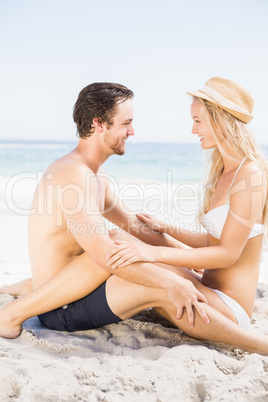 Young couple sitting face to face on the beach