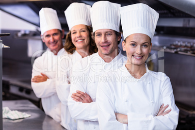 Happy chefs team standing together in commercial kitchen