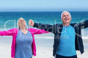 Mature couple outstretching their arms together
