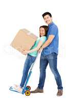 Man holding woman standing on luggage trolley