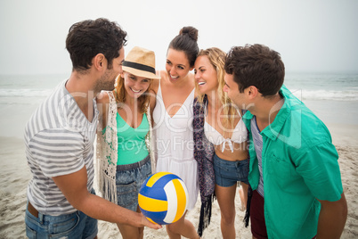 Group of friends with beach ball having fun on the beach