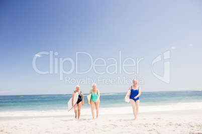 Senior woman friends holding surfboard