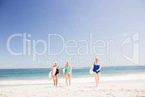 Senior woman friends holding surfboard