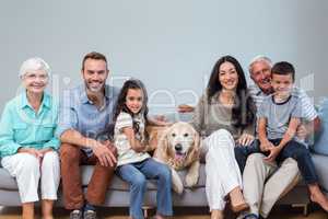 Family sitting on sofa with dog