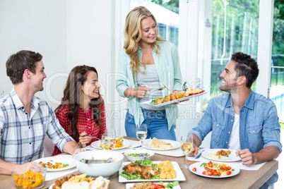 Woman serving food to friends