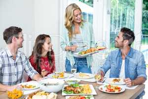 Woman serving food to friends