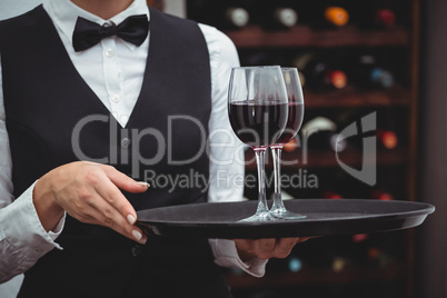 Waitress holding a tray with glasses of red wine