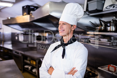 Happy male chef standing with arms crossed