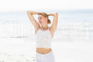 Beautiful woman stretching her arms on the beach