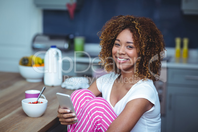 Happy young woman using smartphone with food