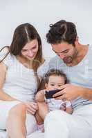 Happy couple enjoying with baby on bed