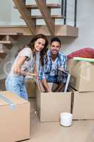 Portrait of smiling couple unpacking computer from cardboard box