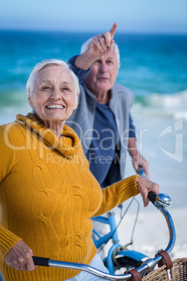 Senior couple with bikes pointing