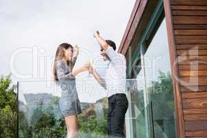 Couple dancing while drinking cocktails in balcony