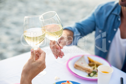 Close up of a couple toasting with white wine