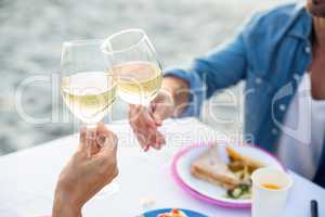 Close up of a couple toasting with white wine