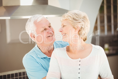 Active senior couple embracing in kitchen