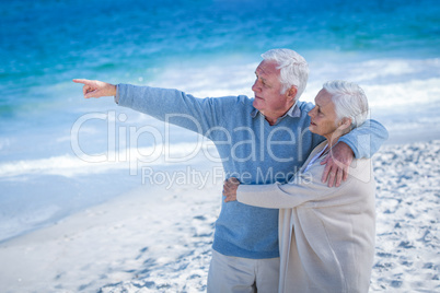 Senior couple embracing and pointing