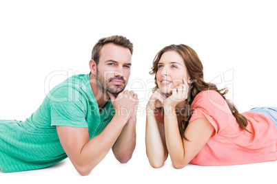 Thoughtful young couple lying on floor looking away