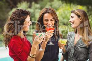 Female friends laughing while drinking cocktail