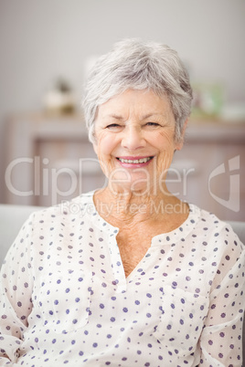 Close-up portrait of senior woman sitting on sofa