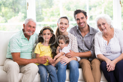 Portrait of smiling family with baby while sitting on sofa