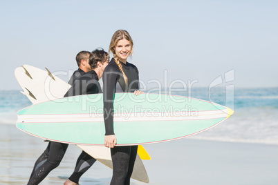 Portrait of surfer woman with surfboard standing on the beach