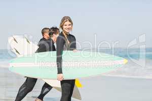 Portrait of surfer woman with surfboard standing on the beach