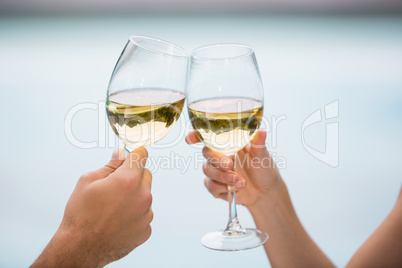 Cropped hands of couple toasting white wine
