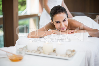 Portrait of young woman receiving massage at health spa