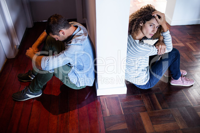 Couple sitting on opposite sides of the wall
