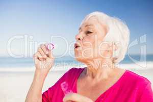 Senior woman making bubbles with a bubble wand
