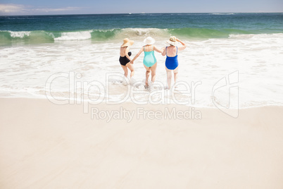 Senior woman friends running into water