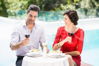Couple holding red wine glasses