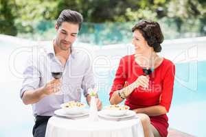 Couple holding red wine glasses