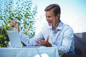 Happy businessman doing online shopping with laptop and credit c