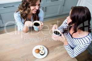 High angle view of female friends holding coffee mugs