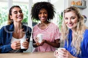 Cheerful female friends drinking coffee