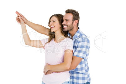 Happy young couple embracing and pointing upward