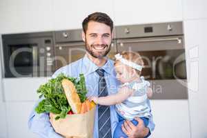 Happy businessman carrying vegetables and daughter