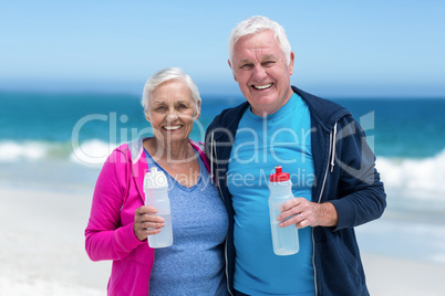 Cute mature couple holding water bottle